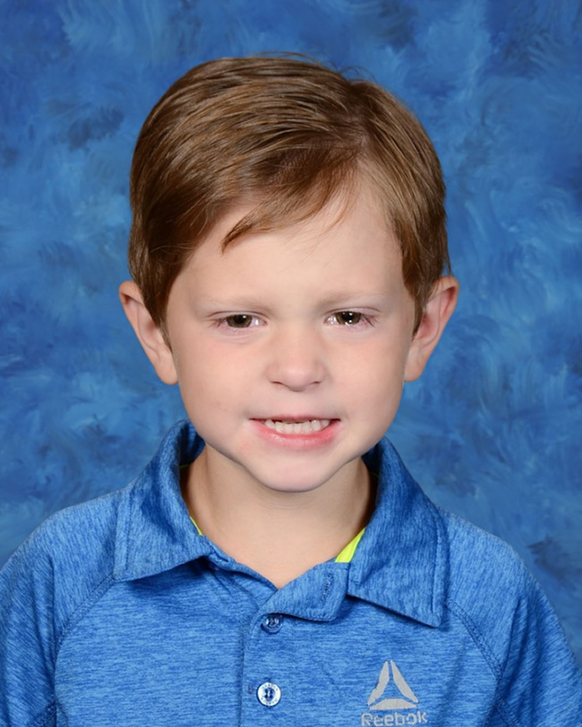 picture of a small boys with a smile in a blue shirt